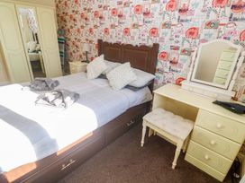 A bedroom with a bed and dressing table at Cherry Tree House in Penzance