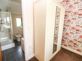 A bathroom featuring a shower, toilet, and mirror wardrobe at Cherry Tree House in Penzance
