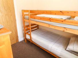 A bedroom with a bunk bed and a door at Cherry Tree House in Penzance