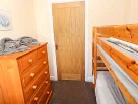 A bedroom with a bunk bed and a wooden dresser at Cherry Tree House in Penzance