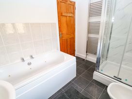 A bathroom with a bathtub and shower at Cherry Tree House in Penzance