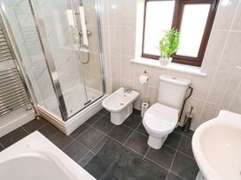 A bathroom with a shower, toilet, bidet, and sink at Cherry Tree House in Penzance