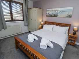 A bedroom with a wooden bed with white linens and towels on the bed at The Old School in Lowick