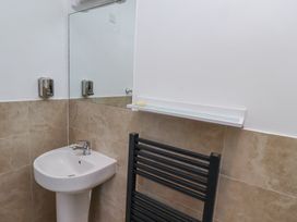 A bathroom sink with a mirror soap dispenser and a black towel rack at The Old School in Lowick