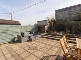 A backyard patio with outdoor furniture and a wooden shed at The Old School in Lowick