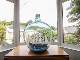 A ship in a bottle on a cabinet with a view at Home in Salcombe