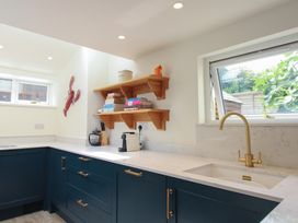 A kitchen with a sink and shelves at Home in Salcombe