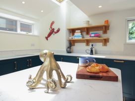 A kitchen with an octopus sculpture, croissant, and mugs at Home in Salcombe
