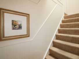 A staircase with carpet and framed artwork at Home in Salcombe
