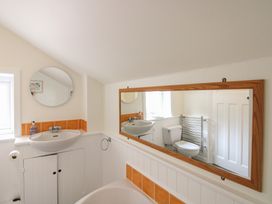 A bathroom with a sink, toilet, and mirror at Home in Salcombe