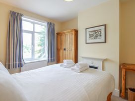 A bedroom with a bed and wardrobe at Home in Salcombe