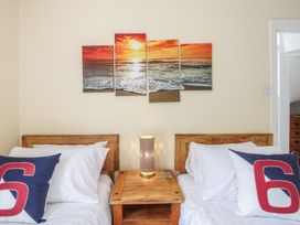 A bedroom with two beds and wall art at Home in Salcombe