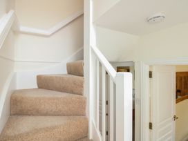 A staircase with a handrail and a door at Home in Salcombe