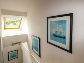 A staircase with pictures on the wall and a skylight at Home, Salcombe