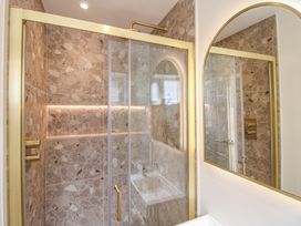 A bathroom with a shower and mirror at Home in Salcombe