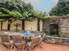 A garden with a wooden table and chairs at Home in Salcombe
