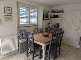 A kitchen with a table and chairs at Mill Stream Cottage in Lower Slaughter near Bourton-On-The-Water
