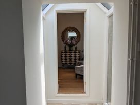 A hallway with a console table and a mirror at Mill Stream Cottage Lower Slaughter near Bourton-On-The-Water