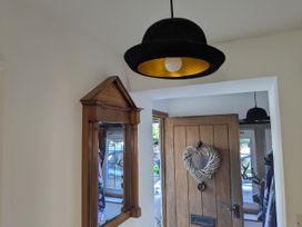 A hallway with a mirror and a wooden door at Mill Stream Cottage in Lower Slaughter near Bourton-On-The-Water
