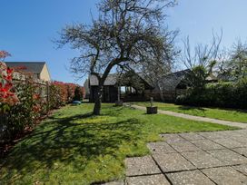 A garden with a tree and pathway at The Tap Room in Kingham