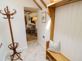 A hallway with a coat rack, bench, and lamp at Wyncliffe in Chipping Campden