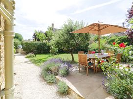 A garden with a table and chairs under an umbrella at Wyncliffe in Chipping Campden