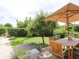 A garden with a table and chairs under an umbrella at Wyncliffe in Chipping Campden