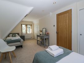 A bedroom with two beds, a dresser, and a mirror at Bell Garden in Stow-On-The-Wold