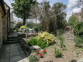 A garden with seating area and flowerbed at Bell Garden Stow-On-The-Wold