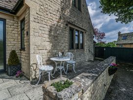 An outdoor seating area with a table and chairs at Bell Garden in Stow-On-The-Wold