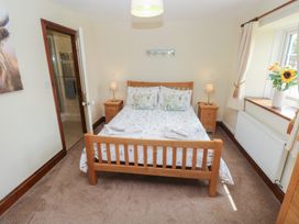 A bedroom with a bed and bedside tables at The Old Dairy in Maenclochog