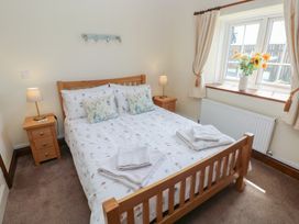 A bedroom with a bed and bedside tables at The Old Dairy in Maenclochog