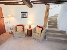 A living room with two chairs and a lamp at Burnside Cottage in Braithwaite