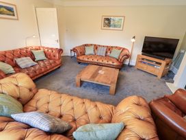 A living room with leather sofas and a wooden coffee table at Hazelmere in Keswick
