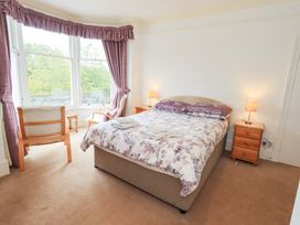 A bedroom with a bed and chair at Hazelmere in Keswick