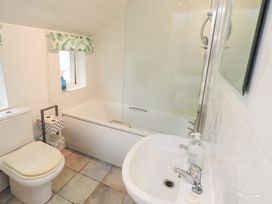 A bathroom with a toilet, bathtub, sink, and storage at Hazelmere in Keswick