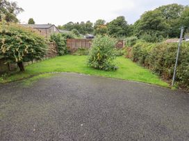 A garden with grass, trees, and a fence at Hazelmere in Keswick