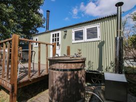 A shepherd hut with a wooden hot tub on a deck at Aston - Shepherd Hut Aston On Clun