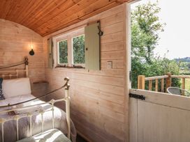 A bedroom with a bed and a window at Aston - Shepherd Hut Aston On Clun