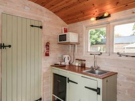 A kitchen with a sink and microwave at Aston - Shepherd Hut in Aston On Clun