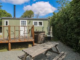 A outdoor area with a shepherd hut and wooden deck at Aston - Shepherd Hut Aston On Clun