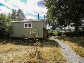 A shepherd hut with a pathway and trees at Aston - Shepherd Hut Aston On Clun