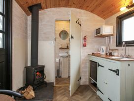 A kitchen with a stove and sink at Aston - Shepherd Hut Aston On Clun