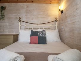 A bedroom with a bed and a nightstand at Aston - Shepherd Hut in Aston On Clun
