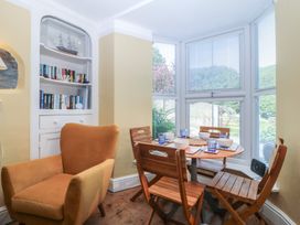 A dining room with a table set for meals at Maenllwyd in Borth-Y-Gest near Porthmadog