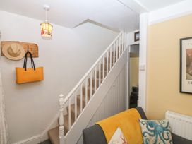 A hallway with stairs and a light fixture at Maenllwyd Borth-Y-Gest near Porthmadog
