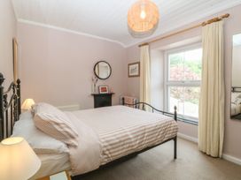 A bedroom with a bed and window at Maenllwyd Borth-Y-Gest near Porthmadog