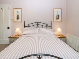 A bedroom with a bed and bedside lamps at Maenllwyd in Borth-Y-Gest near Porthmadog