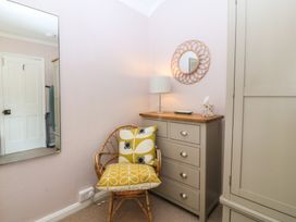 A bedroom with a chair and dresser at Maenllwyd Borth-Y-Gest near Porthmadog
