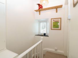 A hallway with a staircase and window at Maenllwyd Borth-Y-Gest near Porthmadog